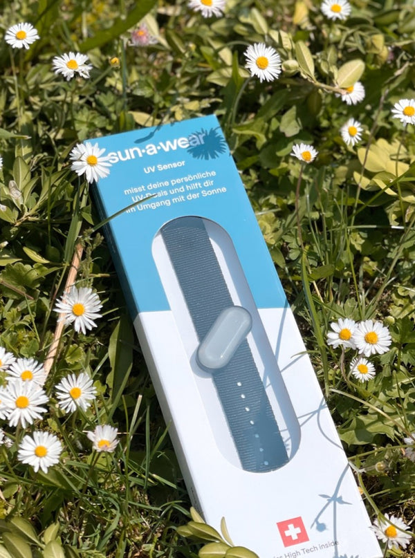 sun-a-wear UV tracker packaging on flowery grass
